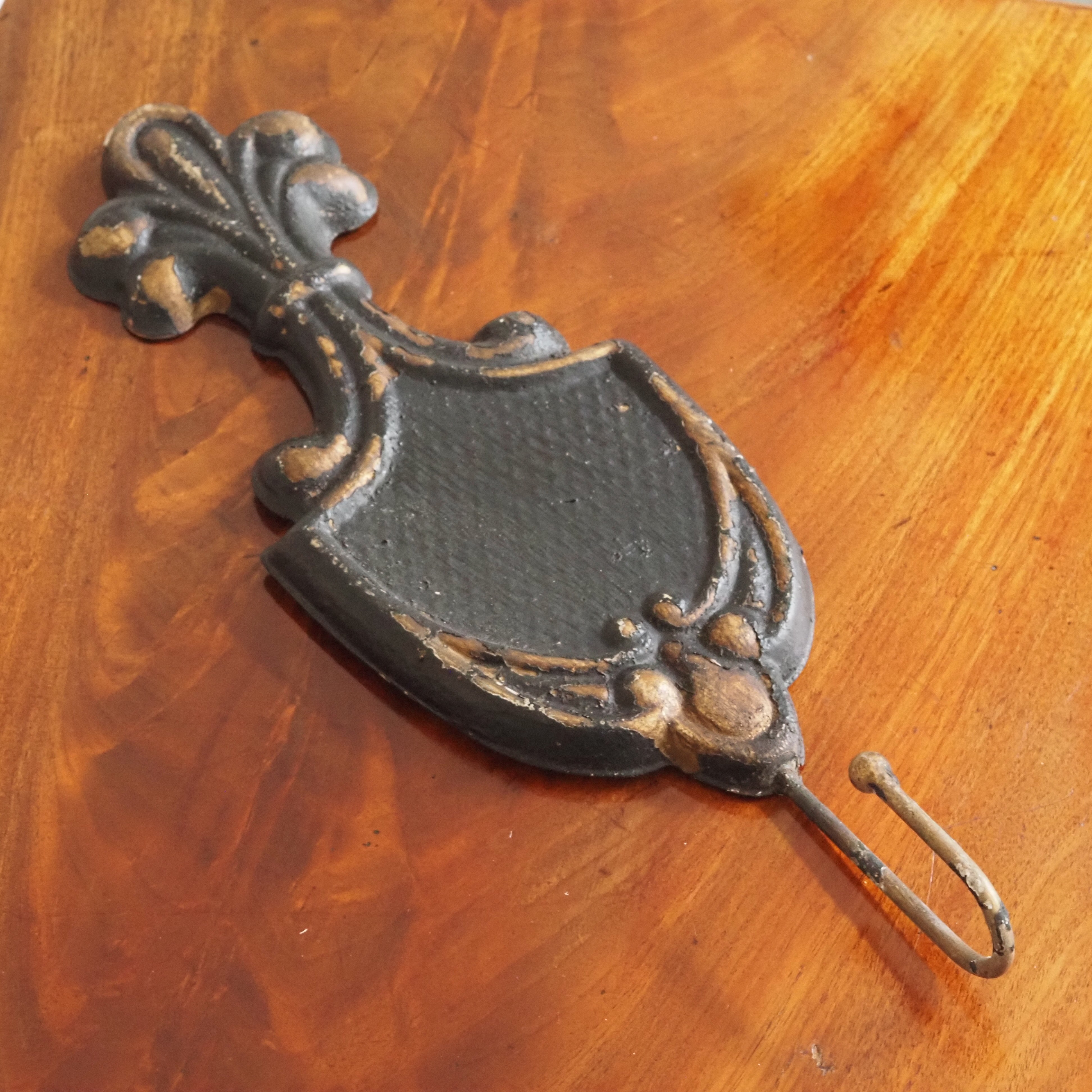 Wandhaken im Fleur-de-Lis-Stil · historisierendes Wandornament in Schwarz-Gold