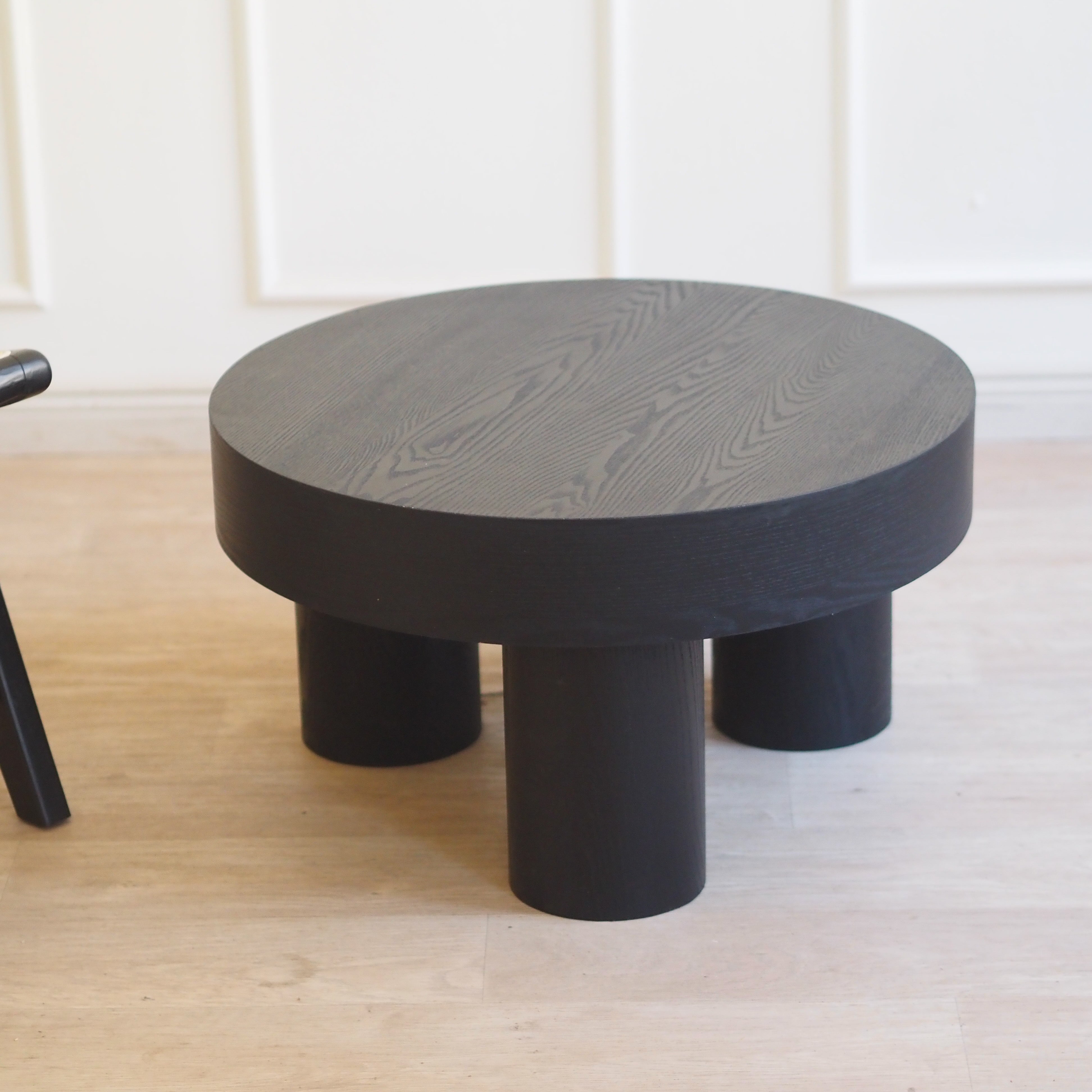 Runder Couchtisch mit zylindrischen Beinen – schwarz gefärbtes Holz, Ø 59 cm