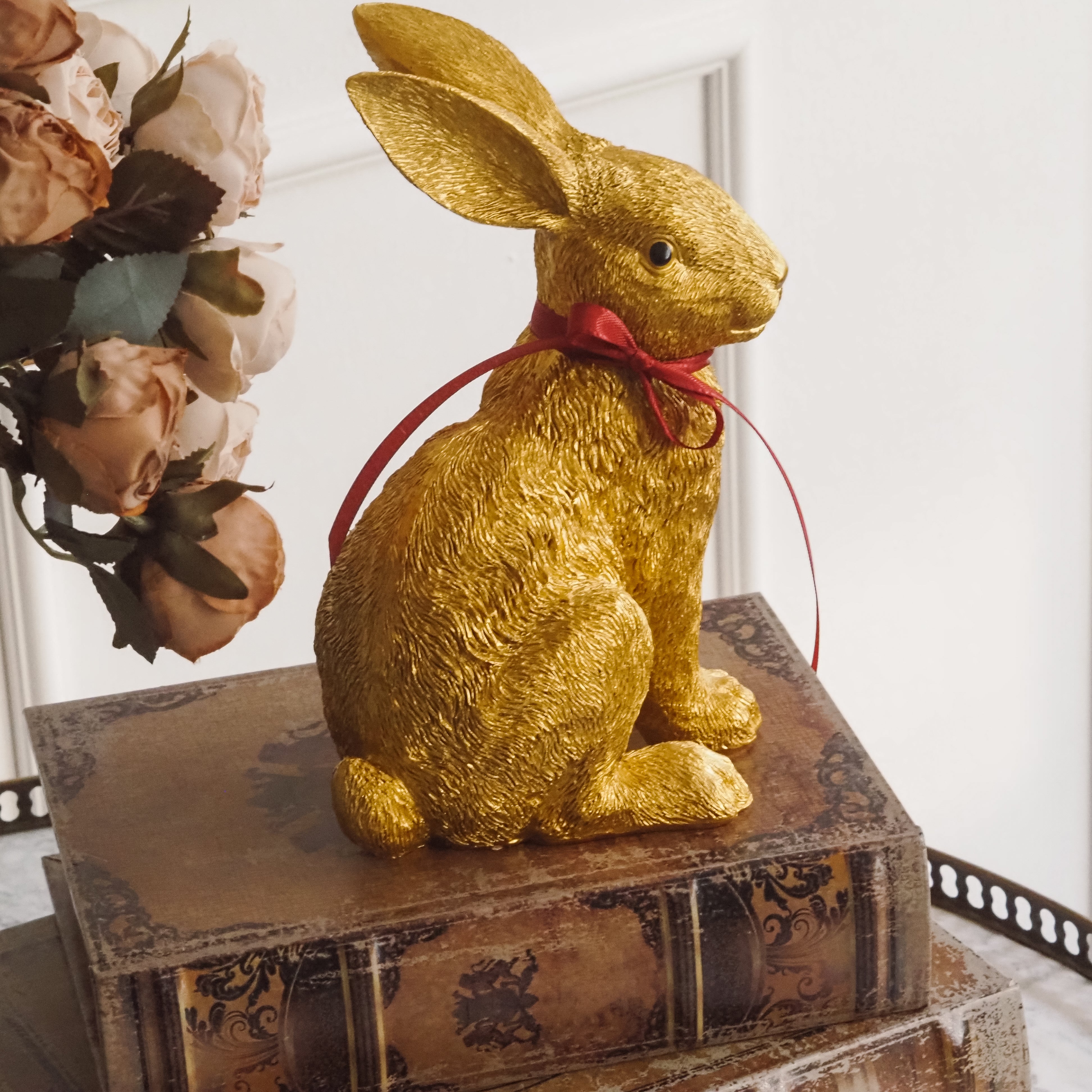 Dekorativer Hase für Ostern · Tierfigur in Goldoptik, Osterhase sitzend mit Schleife