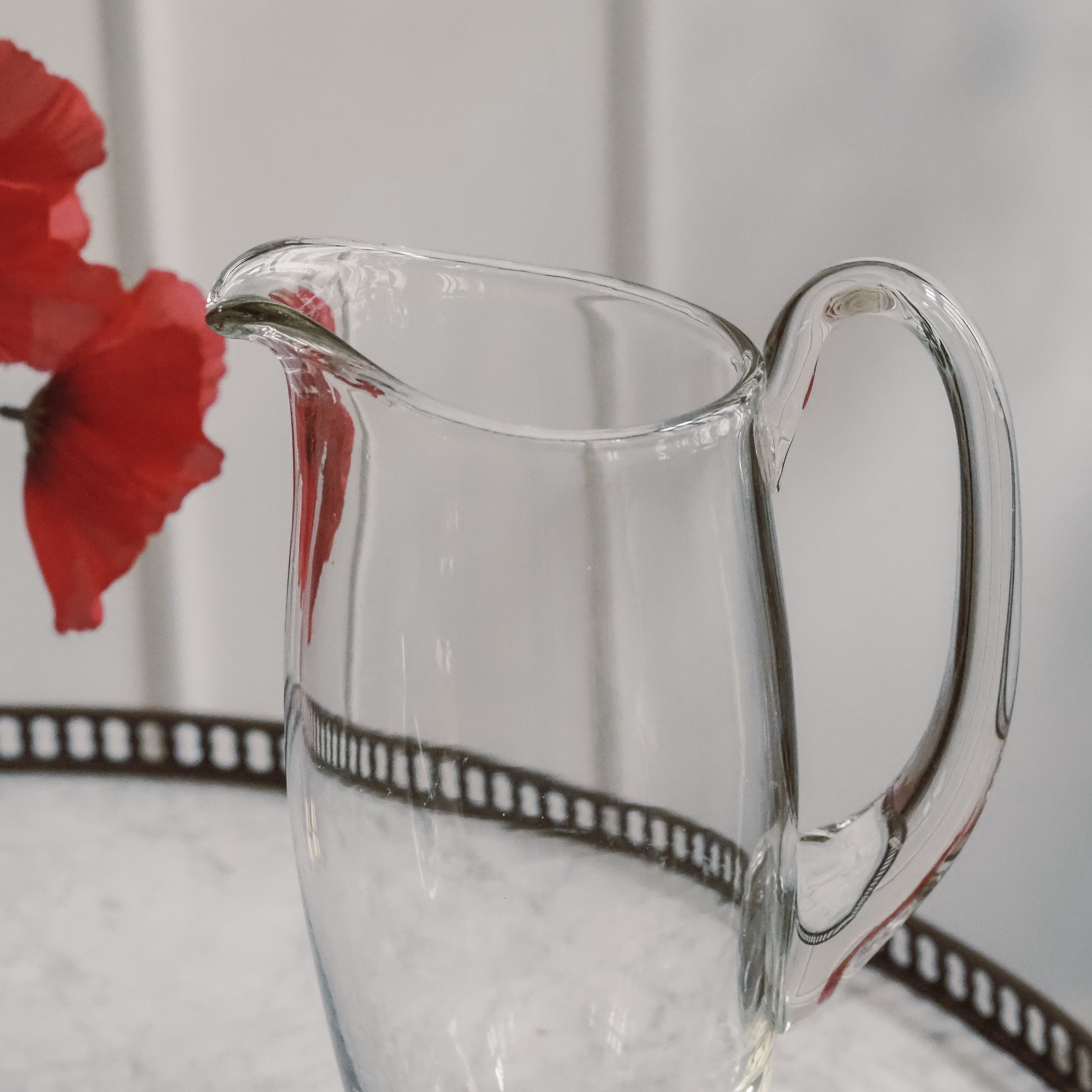 Glaskrug auf Fuß · klassisches Tischgefäß mit Ausguss und Henkel