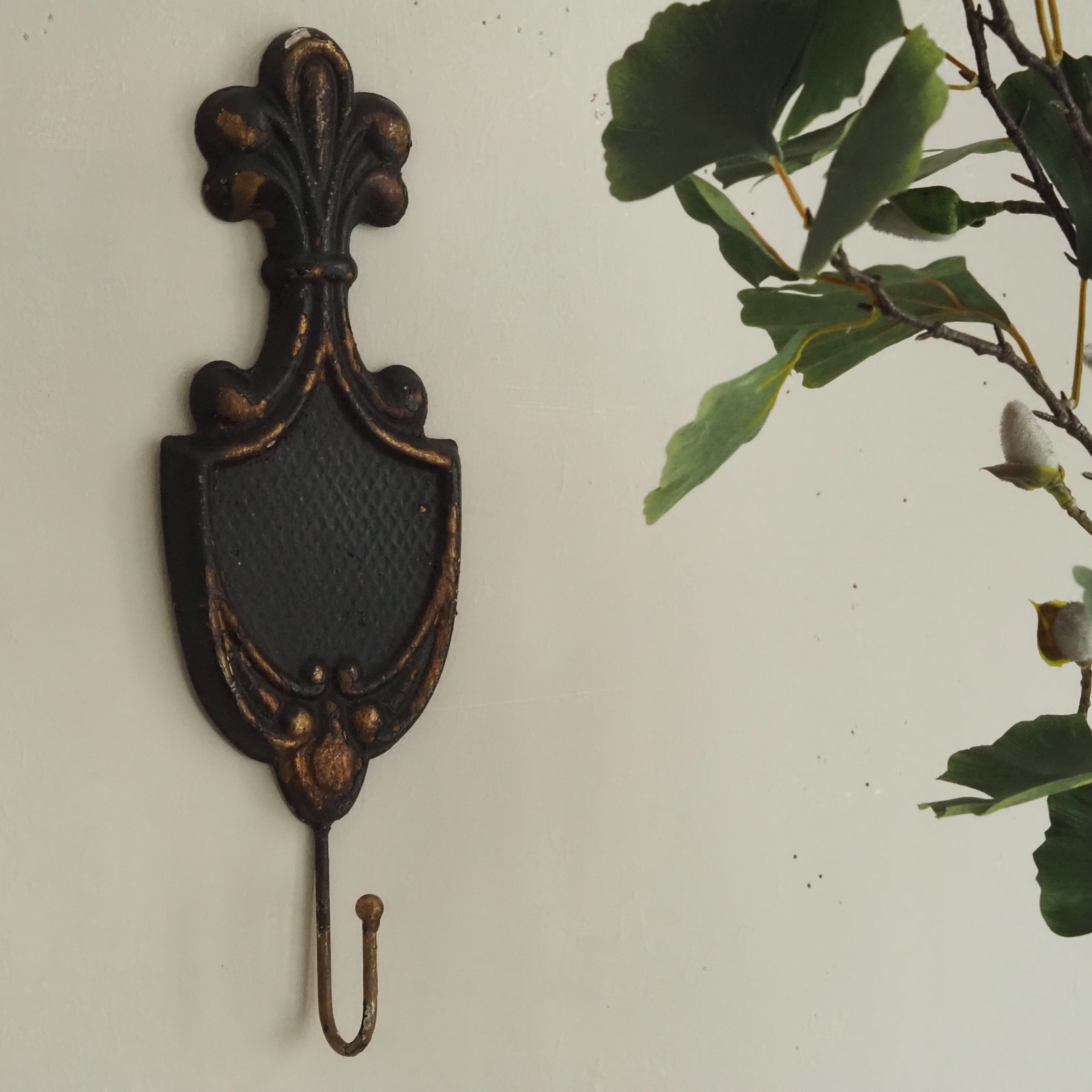 Wandhaken im Fleur-de-Lis-Stil · historisierendes Wandornament in Schwarz-Gold