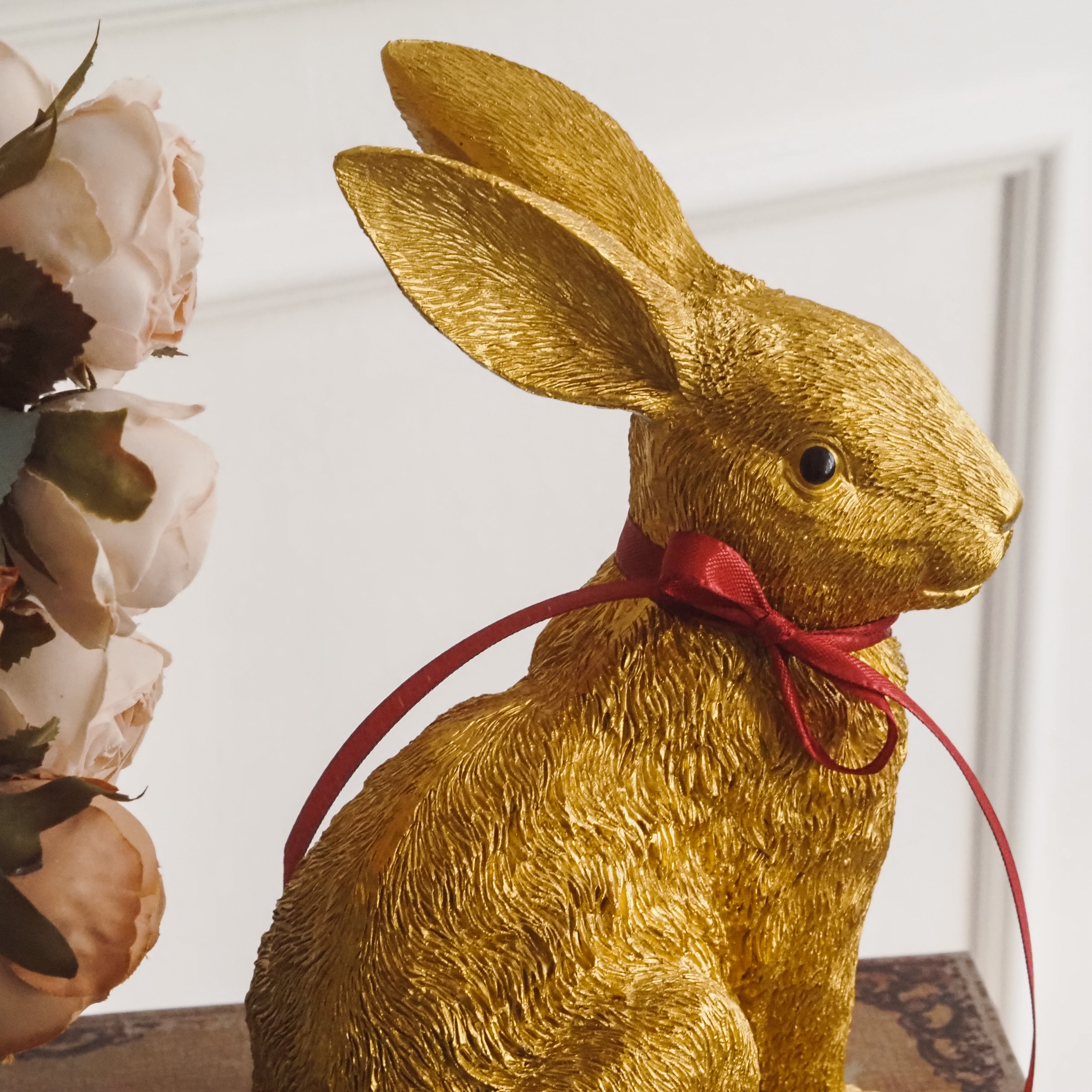 Dekorativer Hase für Ostern · Tierfigur in Goldoptik, Osterhase sitzend mit Schleife